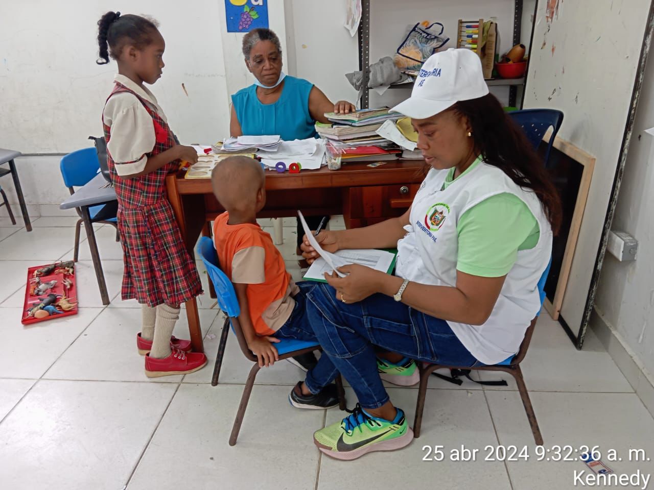 Trabajadora social de Manos Amigas atendiendo a niños de primera infancia en aula educativa, Kennedy